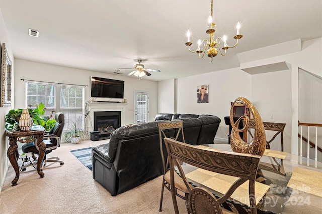 carpeted living room with ceiling fan with notable chandelier