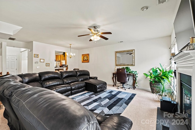 carpeted living room featuring a fireplace and ceiling fan with notable chandelier