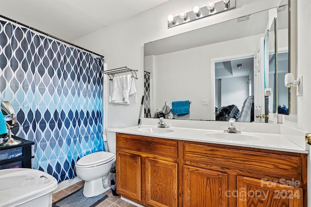 bathroom featuring tile patterned floors, double sink vanity, and toilet