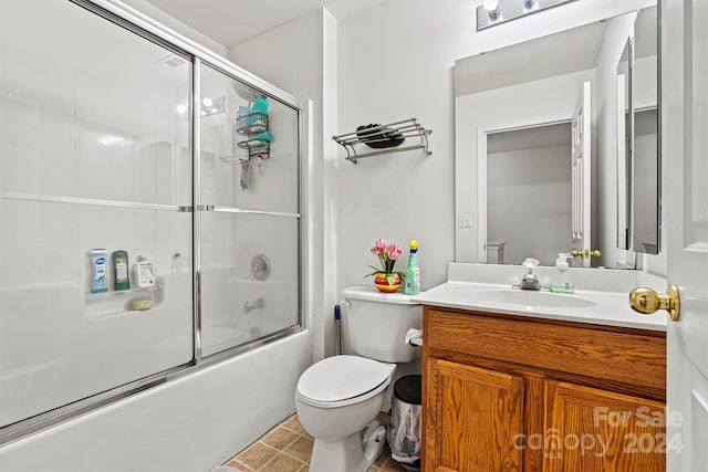 full bathroom featuring tile patterned floors, enclosed tub / shower combo, vanity, and toilet