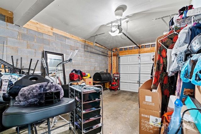 garage featuring concrete block wall and a garage door opener