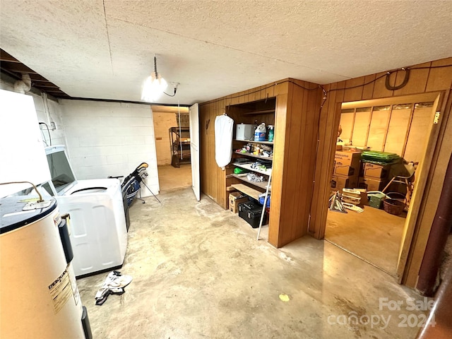 basement featuring a textured ceiling, wood walls, and washer / dryer