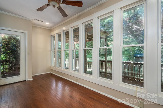 unfurnished sunroom featuring ceiling fan and a wealth of natural light