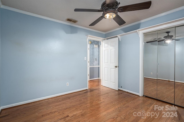 unfurnished bedroom with crown molding, hardwood / wood-style floors, a closet, ceiling fan, and a textured ceiling