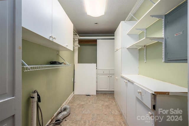 laundry area with stone finish floor and electric panel