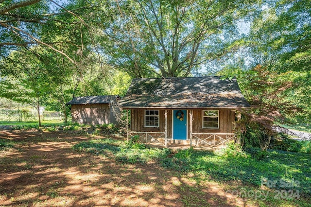 view of front of property with an outbuilding and fence