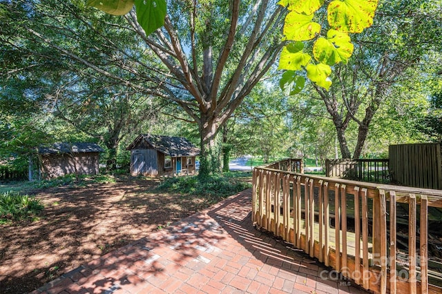 view of patio with an outbuilding, a deck, and a shed