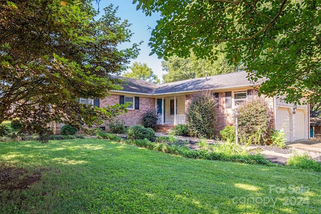 ranch-style home with a garage, a front yard, and a porch