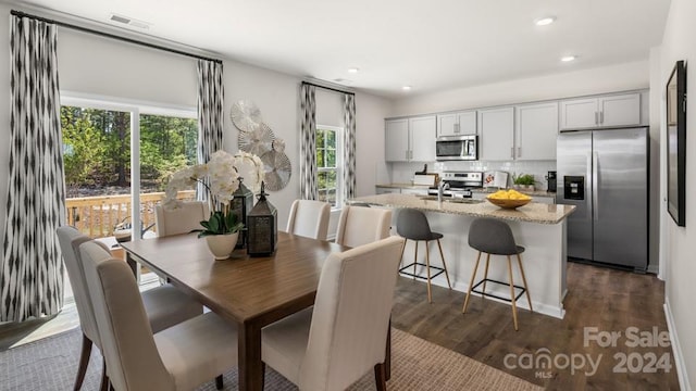 dining space with dark hardwood / wood-style floors and sink