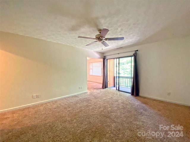 empty room featuring a textured ceiling, ceiling fan, and carpet floors