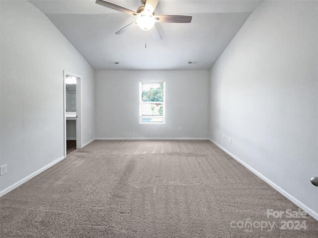 carpeted spare room featuring ceiling fan and lofted ceiling