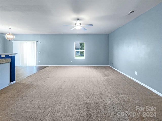 unfurnished living room featuring carpet flooring and ceiling fan