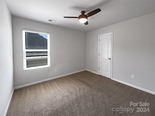 spare room featuring ceiling fan and carpet