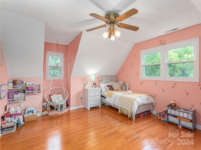 bedroom with ceiling fan, light hardwood / wood-style floors, and vaulted ceiling