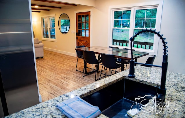 dining room with beamed ceiling and hardwood / wood-style floors