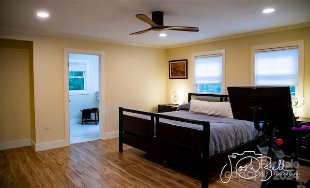 bedroom with hardwood / wood-style floors, ornamental molding, and ceiling fan