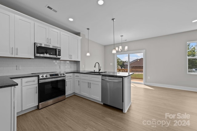 kitchen featuring plenty of natural light, sink, appliances with stainless steel finishes, decorative light fixtures, and white cabinetry