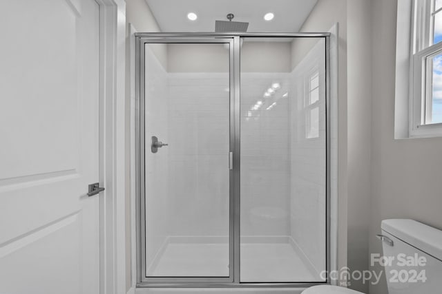 bathroom with toilet and an enclosed shower