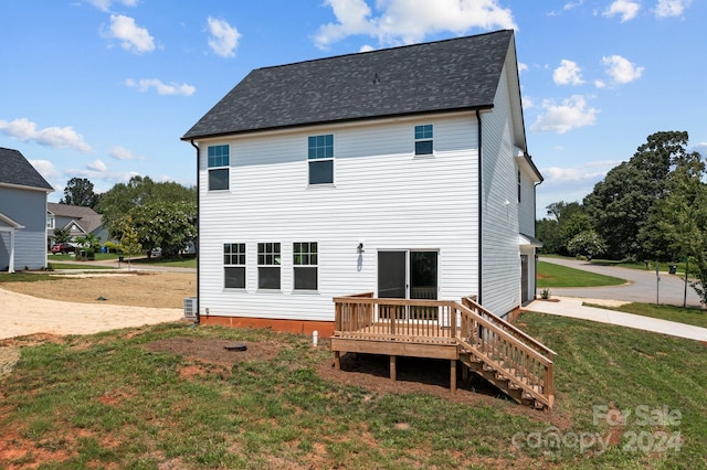 rear view of property with a deck and a yard