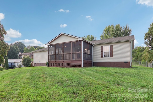 back of property with a sunroom and a yard