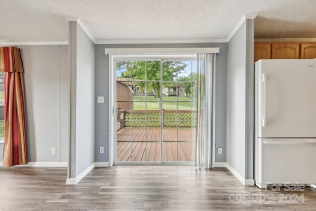 interior space with crown molding, wood-type flooring, and a textured ceiling