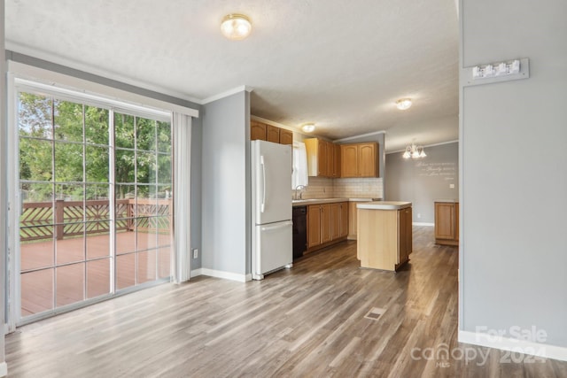 kitchen featuring decorative backsplash, black dishwasher, white fridge, hardwood / wood-style flooring, and crown molding