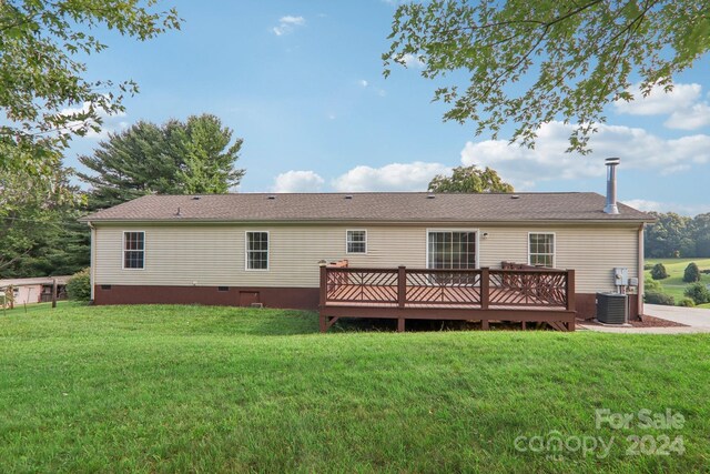 back of house featuring central air condition unit, a deck, and a yard