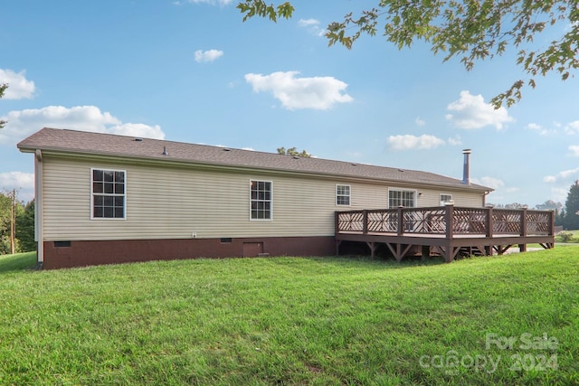 back of house with a wooden deck and a lawn