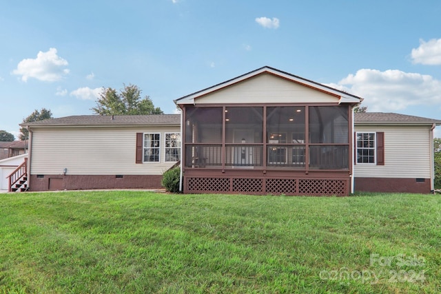 back of property featuring a sunroom and a lawn