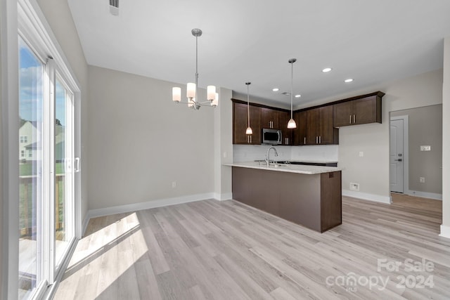 kitchen featuring a wealth of natural light, light hardwood / wood-style flooring, and dark brown cabinets