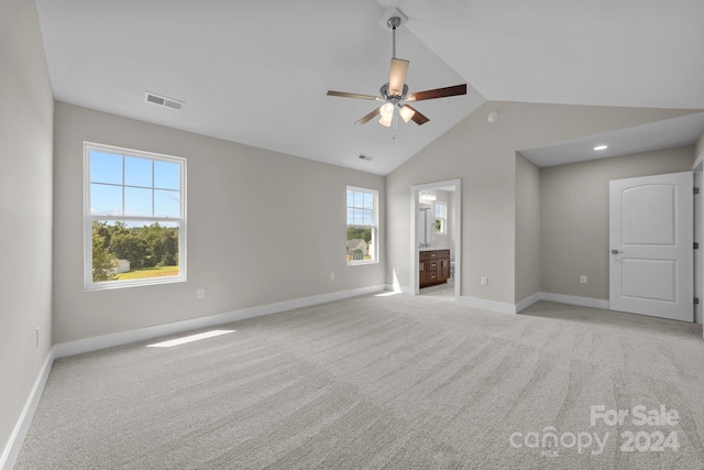 unfurnished room featuring plenty of natural light, ceiling fan, high vaulted ceiling, and light colored carpet