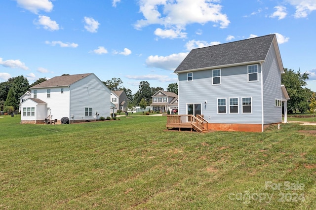 rear view of house with a yard and a deck