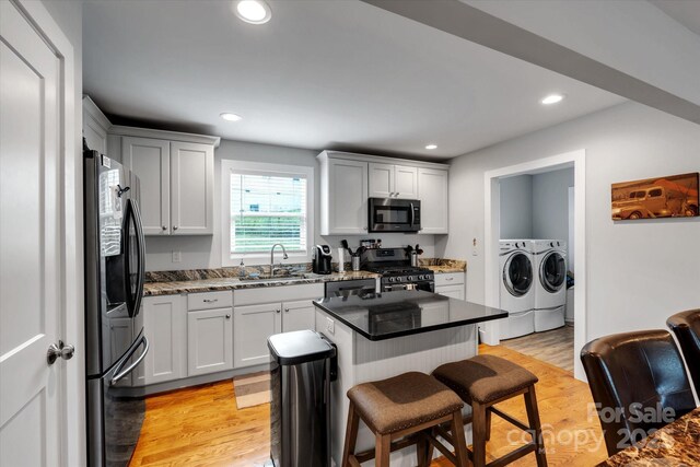 58 Greenwood Fields Dr, Asheville, NC 28804 - kitchen featuring a breakfast bar area, separate washer and dryer, a sink, appliances with stainless steel finishes, and a center island