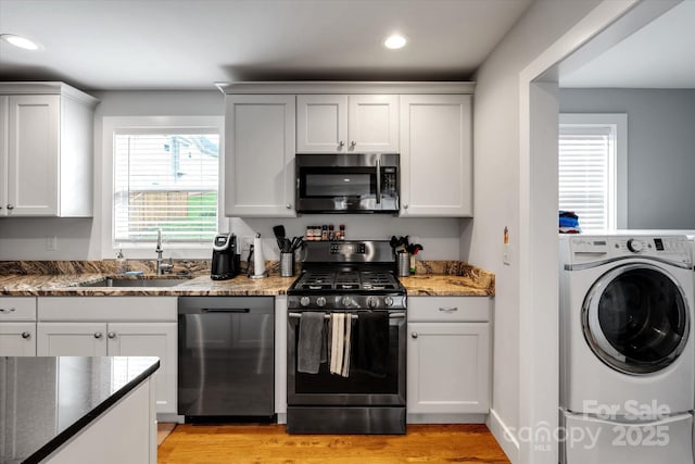 58 Greenwood Fields Dr, Asheville, NC 28804 - kitchen featuring white cabinets, washer / clothes dryer, dark stone countertops, stainless steel appliances, and a sink