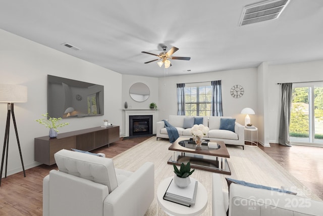 living room with hardwood / wood-style flooring, a wealth of natural light, and ceiling fan