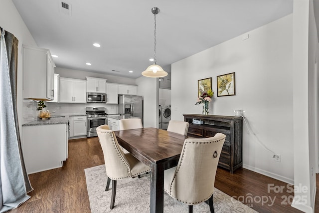 dining space with washer and clothes dryer and dark wood-type flooring