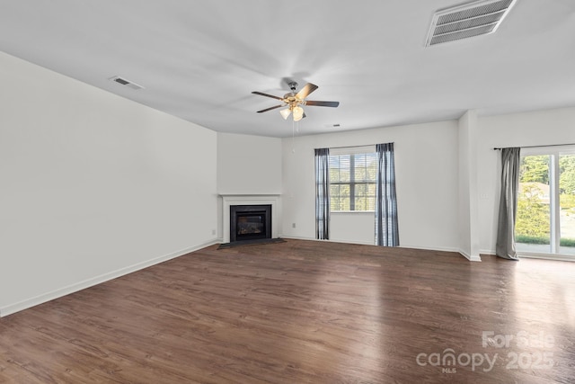 unfurnished living room featuring ceiling fan, plenty of natural light, and dark hardwood / wood-style floors