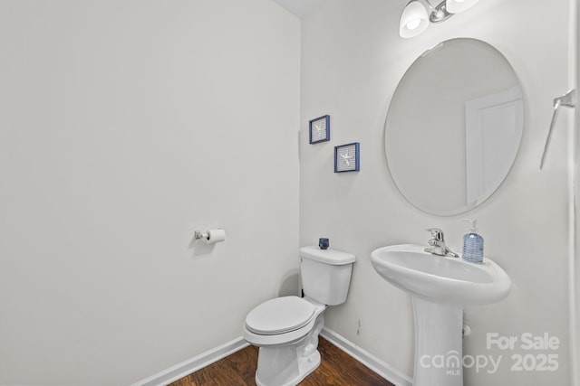 bathroom featuring hardwood / wood-style flooring and toilet