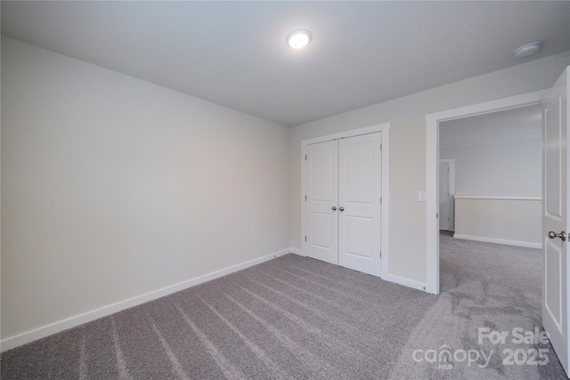 unfurnished bedroom with a closet, baseboards, and carpet flooring