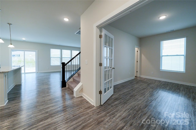 empty room with recessed lighting, dark wood finished floors, stairway, and baseboards