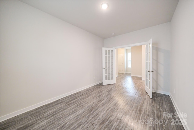 unfurnished room featuring french doors, dark wood-style flooring, and baseboards