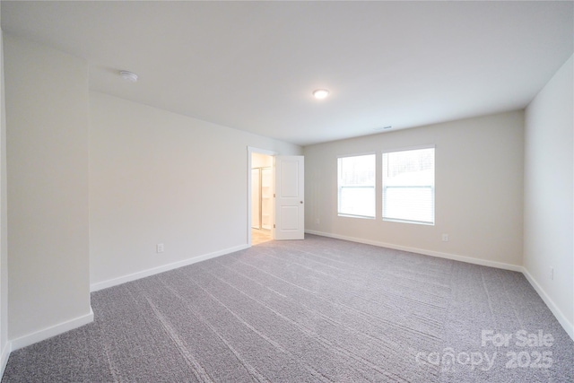 carpeted spare room featuring visible vents and baseboards