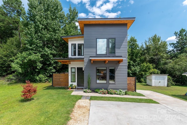 contemporary home with a front lawn and a storage shed