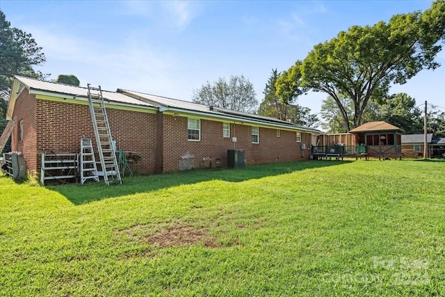 rear view of house with a wooden deck and a yard