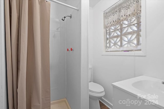 full bath featuring toilet and curtained shower