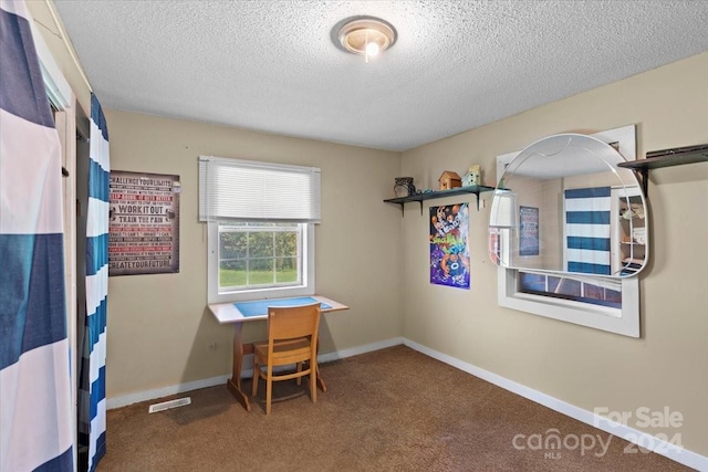 office area with a textured ceiling, carpet flooring, visible vents, and baseboards