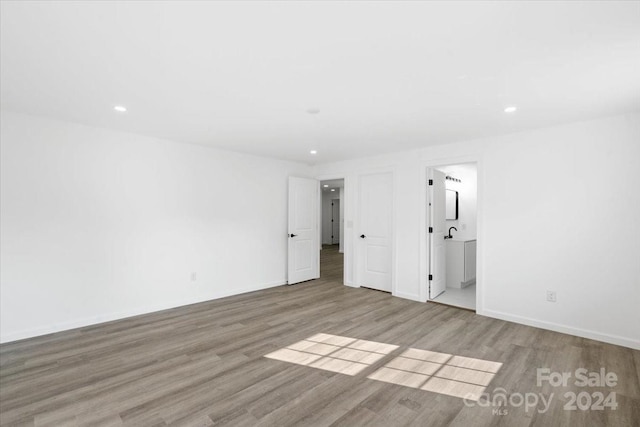 unfurnished bedroom featuring light wood-type flooring, baseboards, and recessed lighting