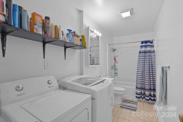 laundry area with laundry area, washing machine and clothes dryer, and light tile patterned floors