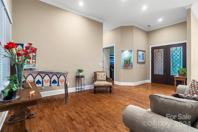 entryway with french doors, crown molding, hardwood / wood-style flooring, and a high ceiling