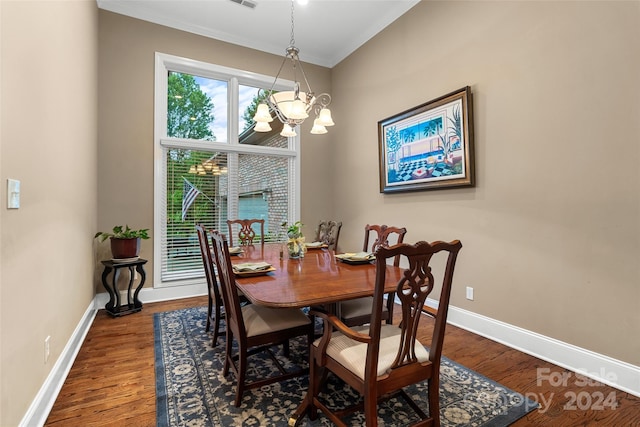 dining area with wood-type flooring and an inviting chandelier